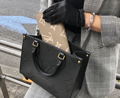 ルイヴィトンのバッグに財布を入れる女性