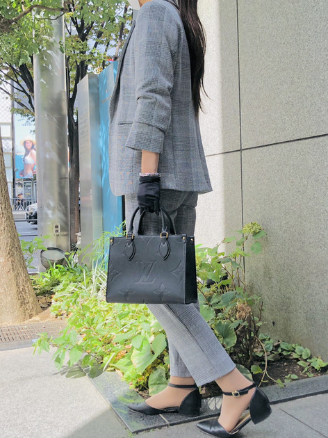 ルイヴィトンのバッグを持つスーツ姿の女性